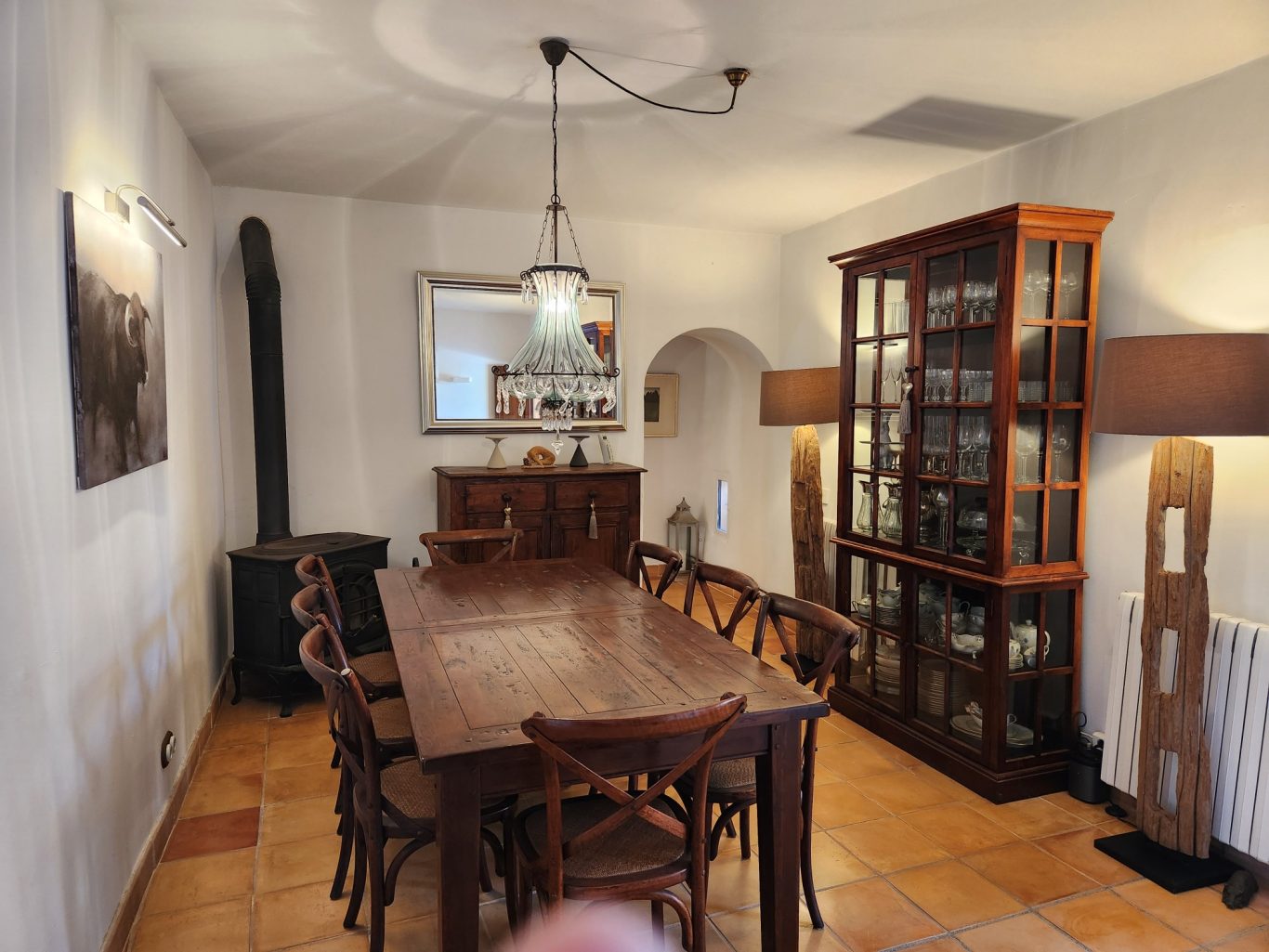Essbereich mit Holztisch, Kamin und Vitrine Esszimmer mit Holztisch, Stühlen, Vitrine und Kamin in hellen Farben.