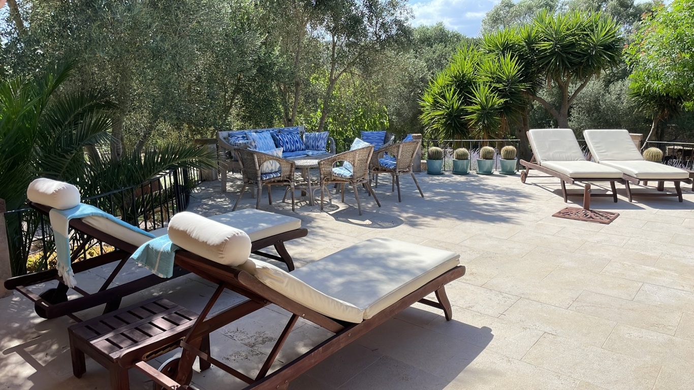 Terrasse mit Sitzplatz und Sonnenliegen am Pool